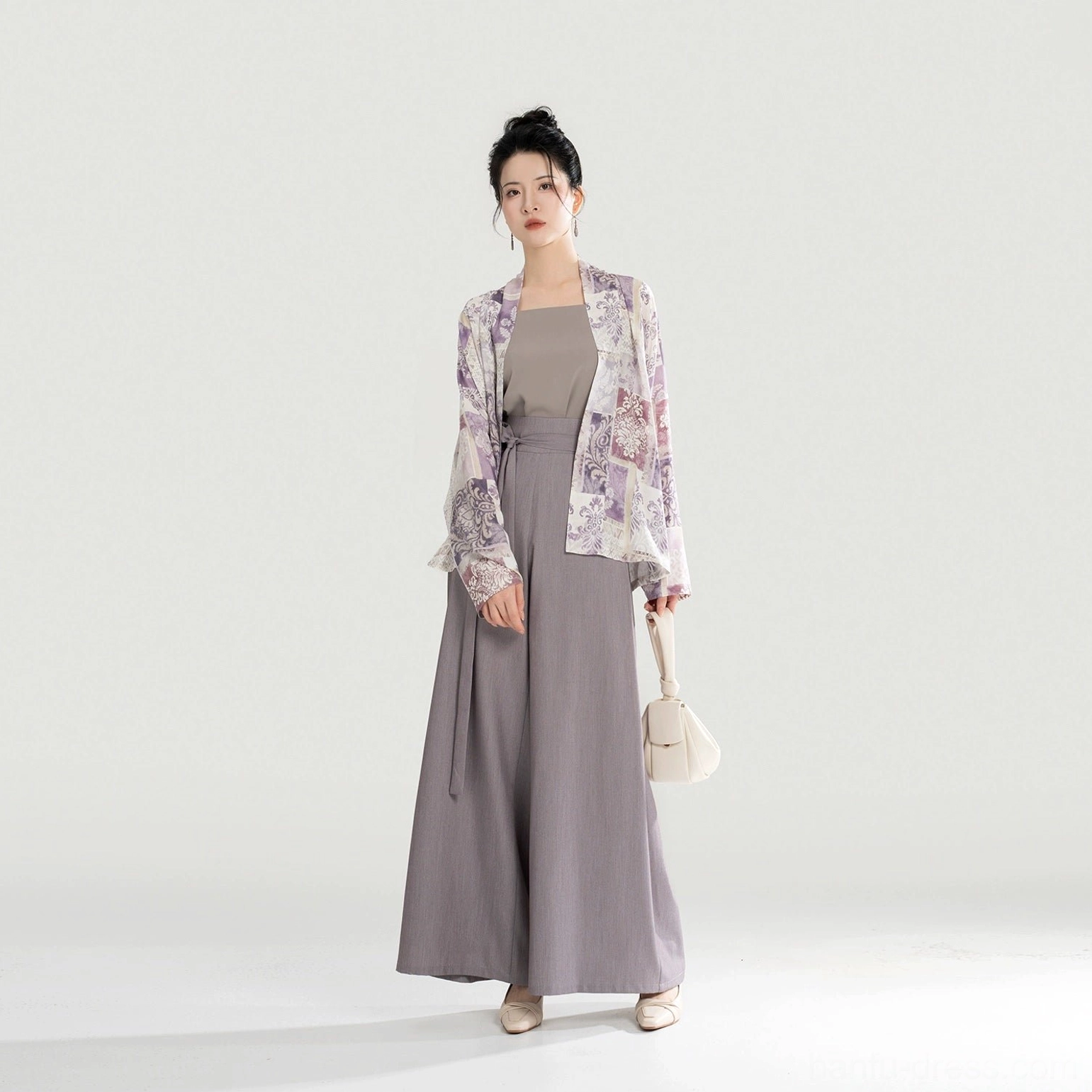 Modern Song-style Hanfu outfit in three-quarter view with high-waisted wide-leg pants waist tie flowing top and beige handbag