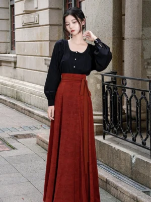 Modern Tang Dynasty Hanfu black sweetheart collar blouse paired with a rust red high-waisted pleated wrap skirt in a three-quarter street view
