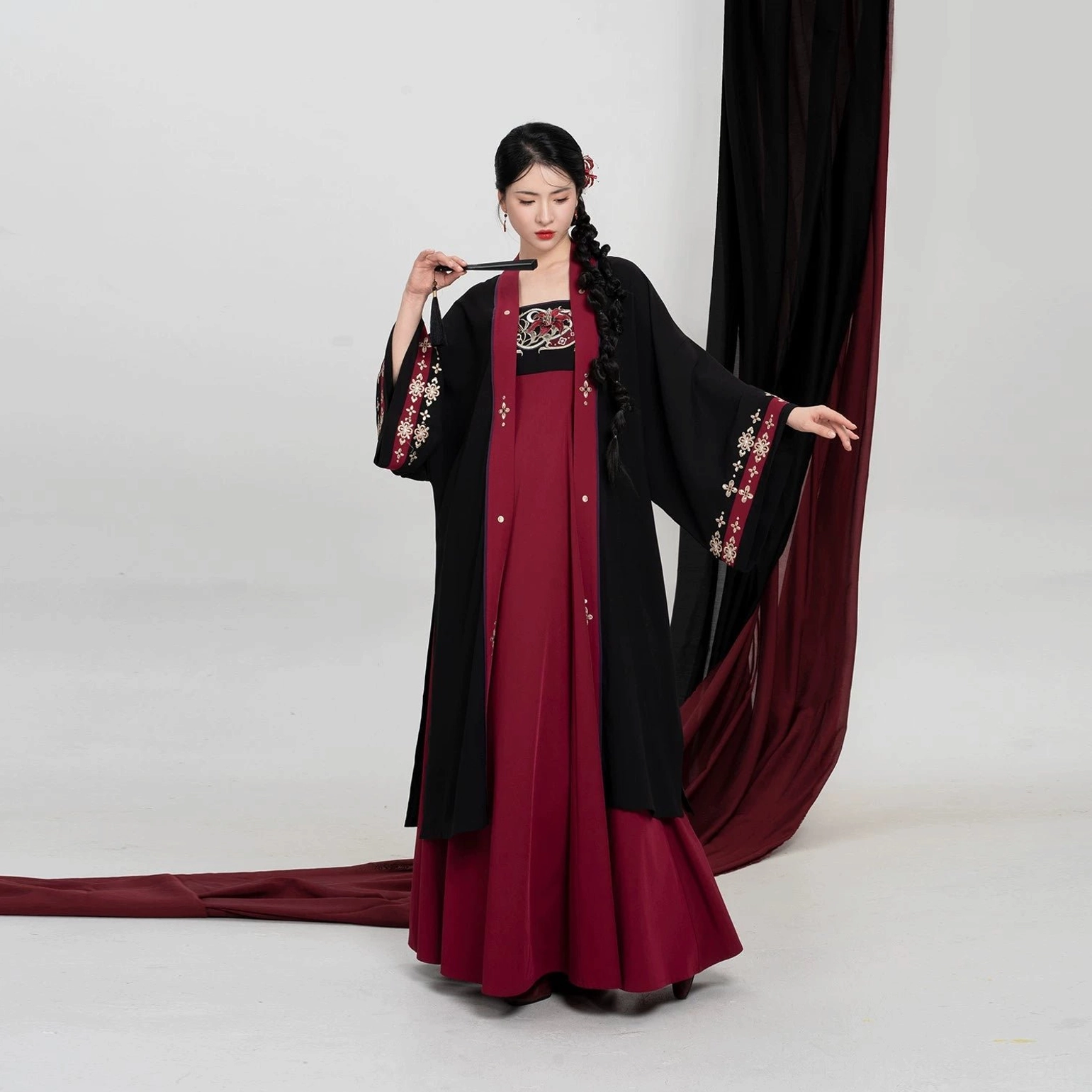 Full-length view of a modern Tang Dynasty Hanfu set with long black Beizi outer robe, high square neckline crimson slip dress, and open sleeve styling
