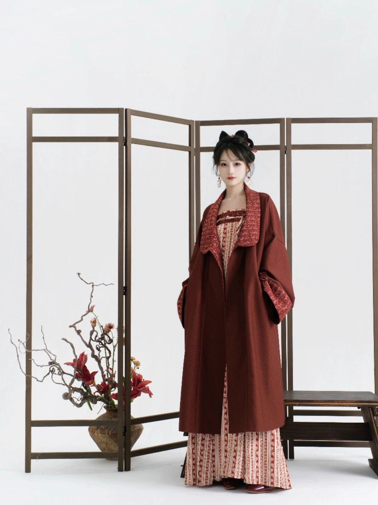 Full-length modern Tang Dynasty Hanfu styling with a burgundy outer coat and beige red striped dress against a folding screen