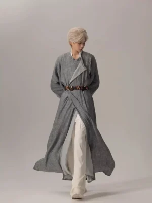 Front three quarter view of a modern Tang Dynasty Hanfu robe in heather grey with oversized sleeves, side split hem, cross-wrap front, and brown waist belt