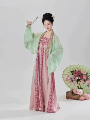 Modern Tang Dynasty Hanfu two-piece set with pink patterned slip dress and mint green sheer cardigan styled with peony flowers and an oil paper umbrella