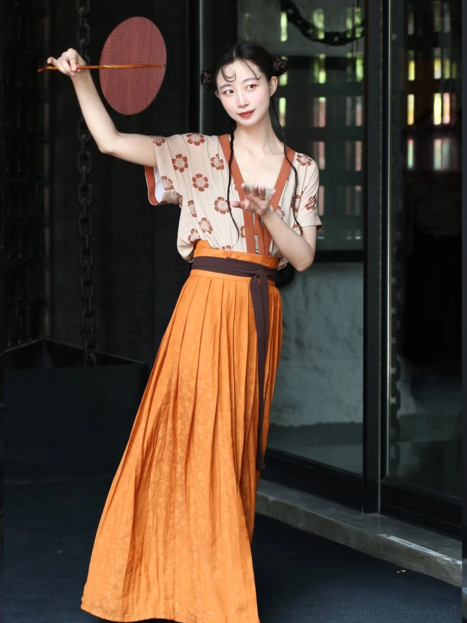 Modern Tang Dynasty Qiyao Ruqun hanfu outfit with apricot floral beizi vest, orange pleated skirt, and brown waist sash