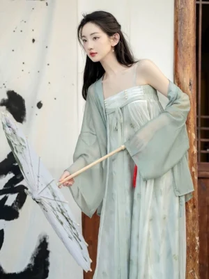 Modern Tang Dynasty inspired sage green Hanfu dress set with floral print, pearl bust decoration, sheer long sleeve outer coat, and traditional Chinese umbrella in a courtyard