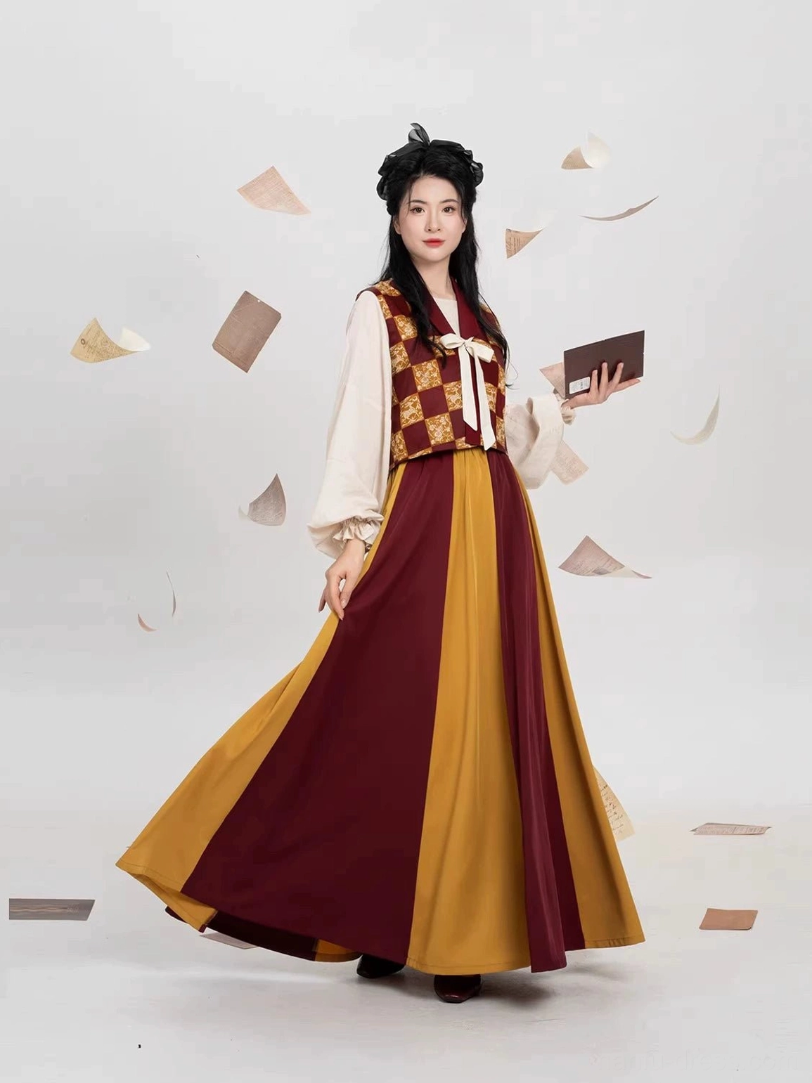 Modern Tang style Hanfu outfit front three-quarter view featuring burgundy patterned beizi overlay cream blouse and mustard yellow color-block maxi skirt