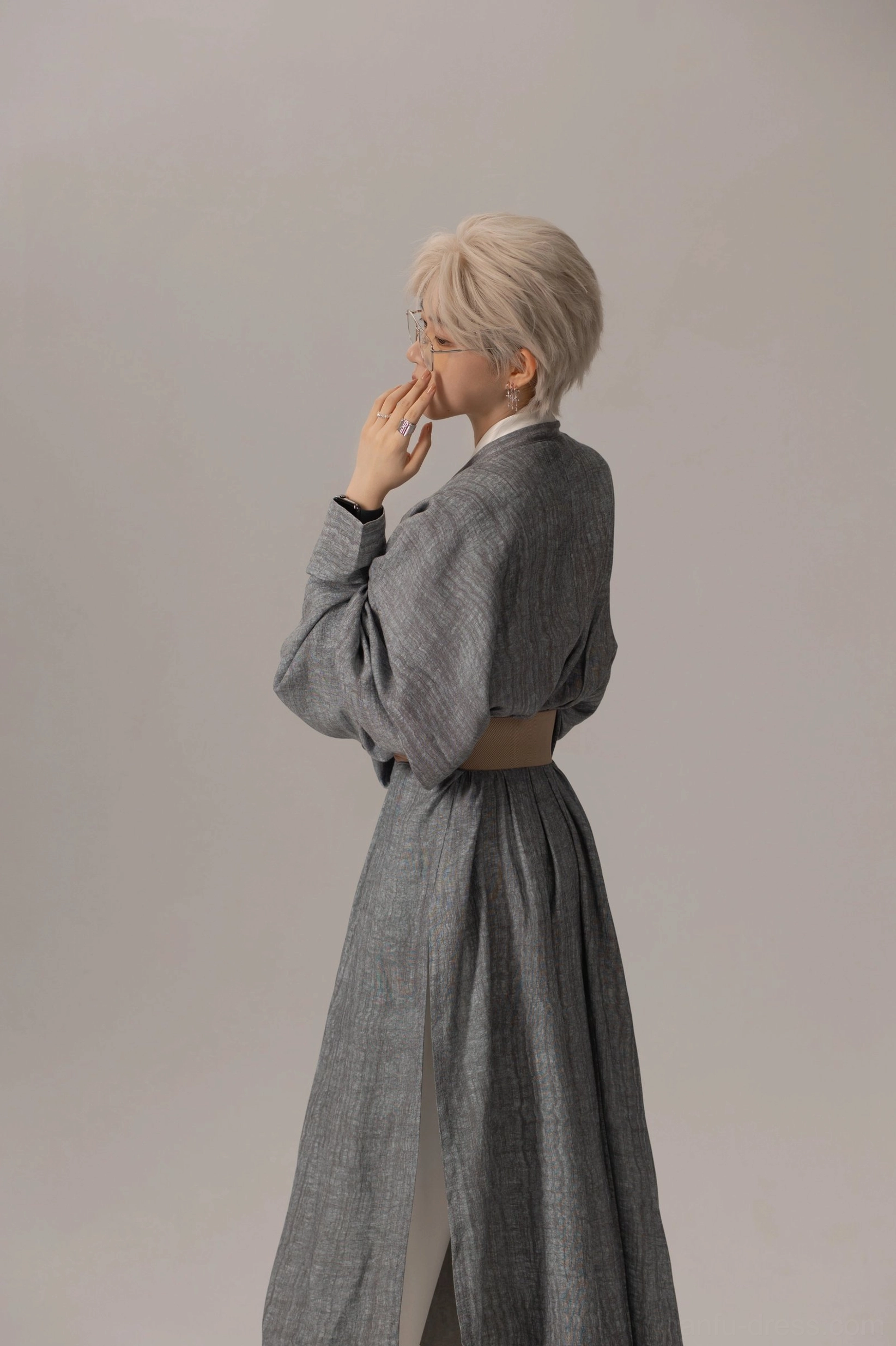 Right side full body view of a modern Tang style Hanfu robe with textured grey fabric, oversized sleeves, long side split, and tan waist belt