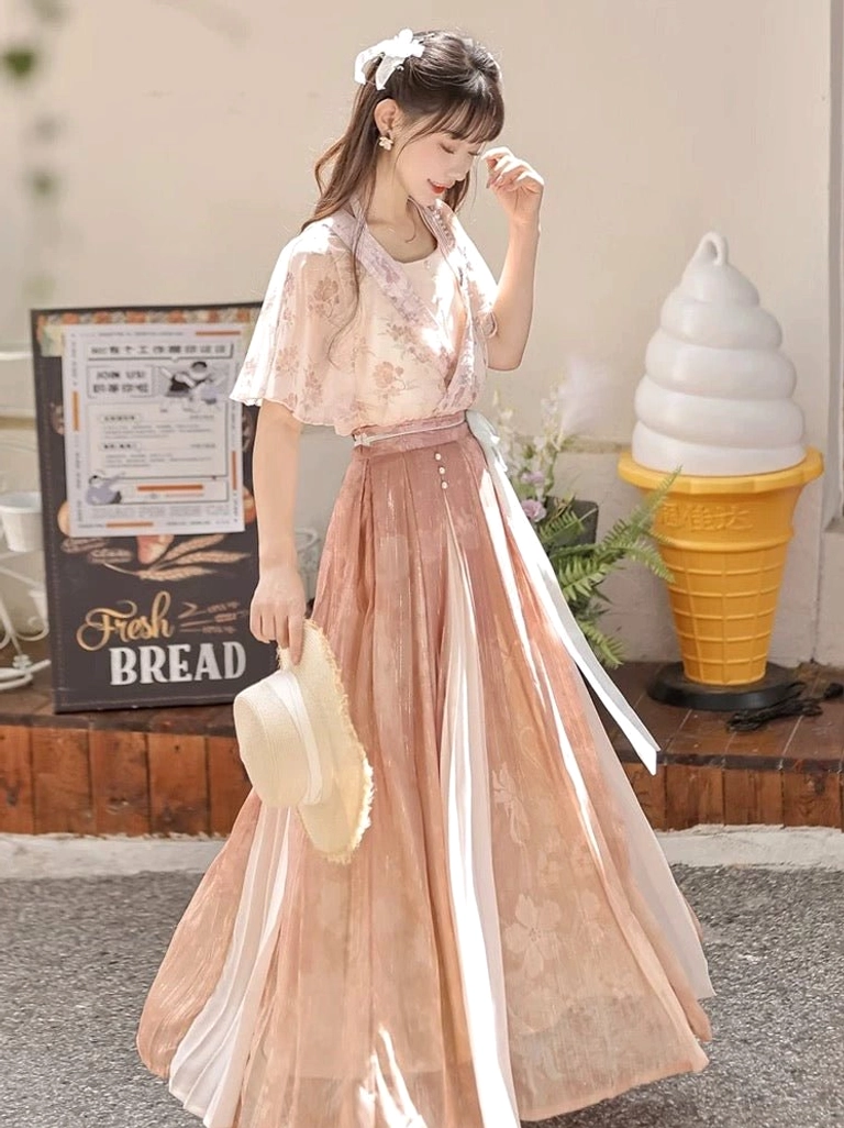 Side three quarter view of a modern Wei-Jin Hanfu dress in soft pink floral chiffon with flowing skirt matching waist sash and elegant layered silhouette