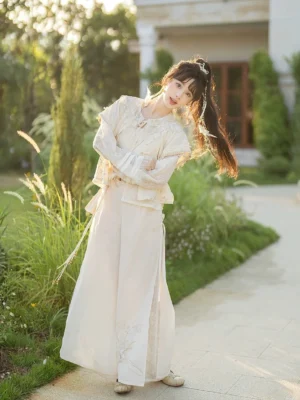 Three-quarter view of a modern Song-style hanfu outfit with layered ruffled collar top, flowing wide-leg pants, cream fabric, and tassel waist sash