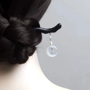 Woman wearing a moon and star Chinese hair stick in a braided chignon hairstyle with the pearl pendant hanging gracefully at the neck