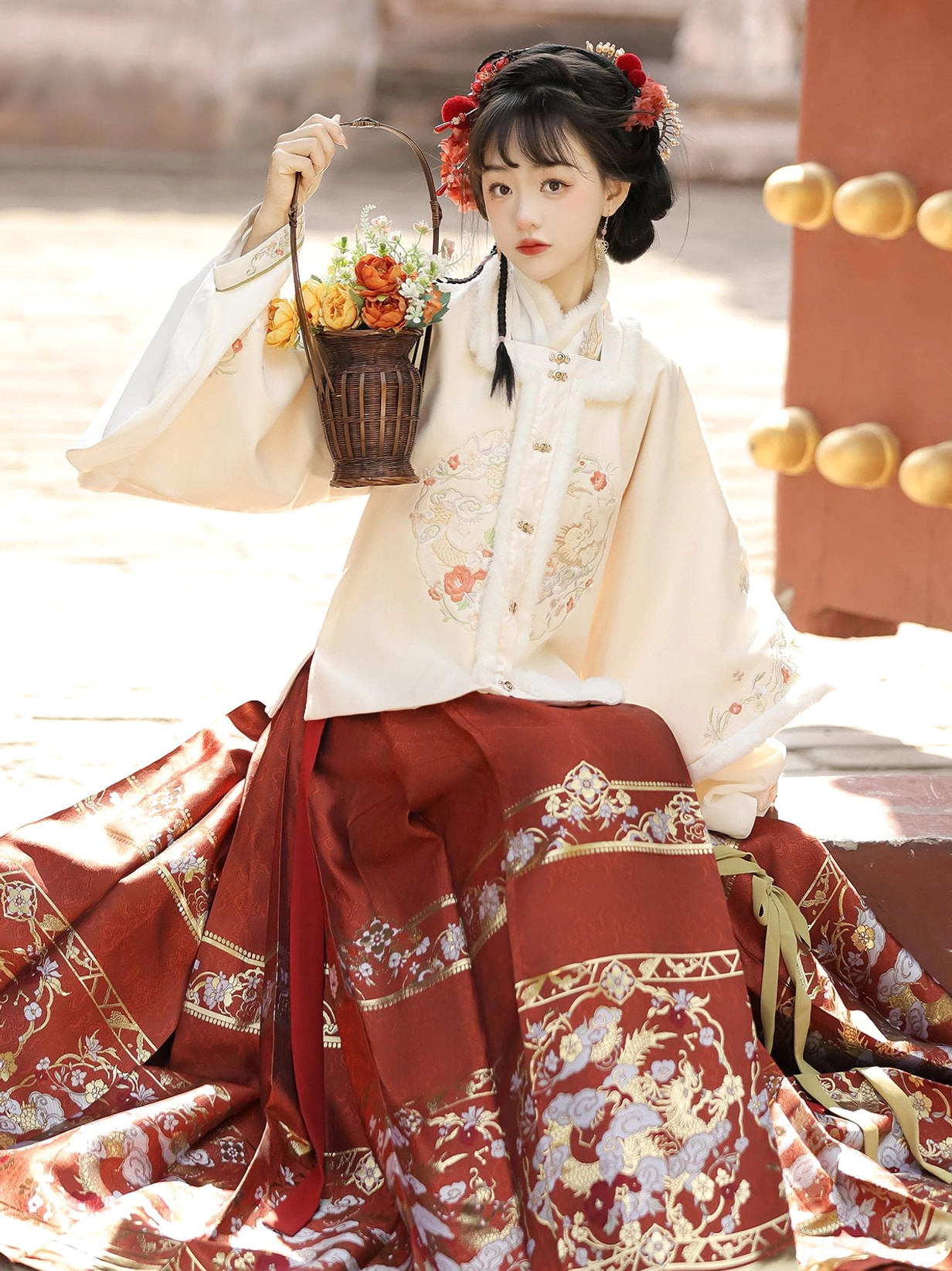 Moonlit Night Chinese New Year Hanfu set featuring an ivory embroidered top and deep red Ming style mamian skirt beside a palace gate