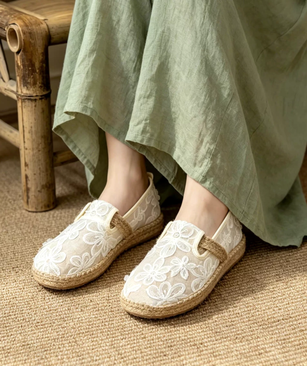 Morning Dew floral mesh Hanfu espadrille Chinese shoes worn with a flowing green dress, showing off-white embroidered slip-on flats and woven sole trim