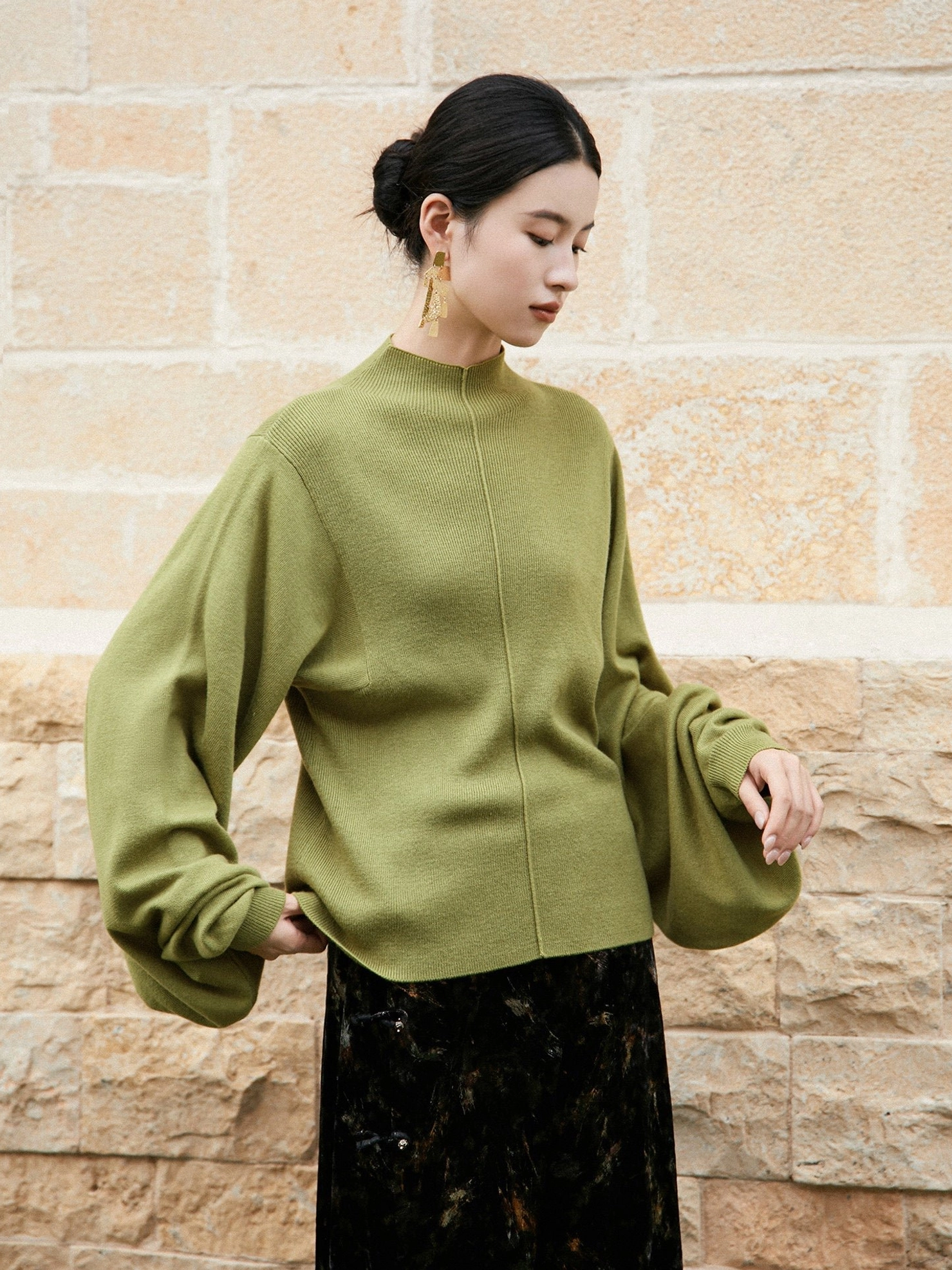 Moss green pipa sleeve modern Hanfu sweater shown from a right three-quarter view with loose lantern sleeves, central front seam, stand collar, and straight hem
