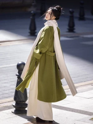Three quarter back view of a moss green winter Hanfu coat with adjustable waist straps and flowing wide sleeves