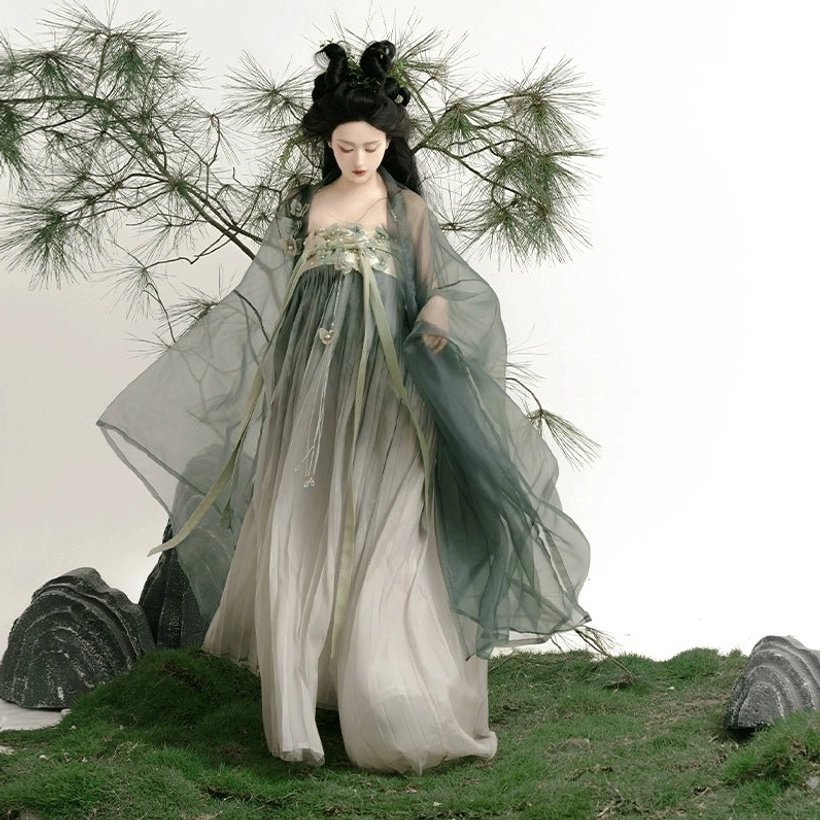 Front walking view of complete Tang Dynasty Hanfu Qixiong Ruqun set with soft green and grey gradient colors, sheer wide sleeves, full pleated skirt, and refined floral chest adornments