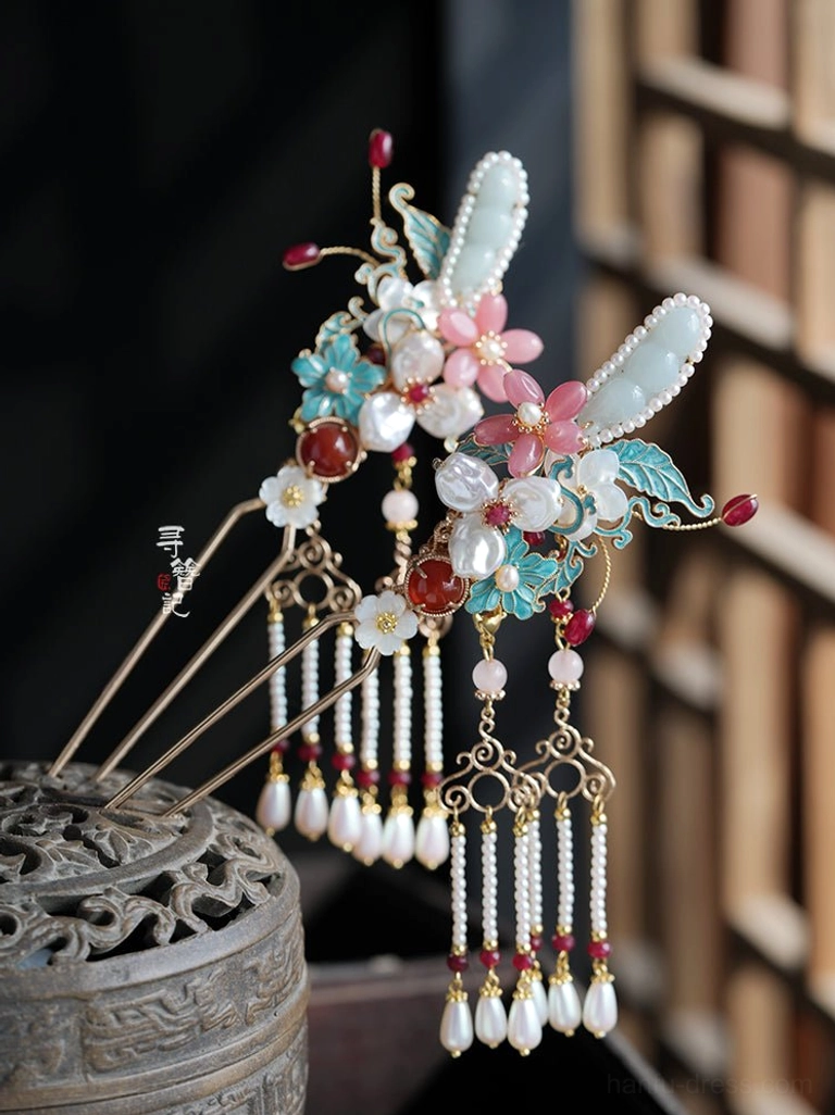 Oblique close-up of matching Hanfu side hanging hairpins with pink flowers blue cloisonne-style leaves imitation jade red beads and pearl tassels displayed on an antique Chinese incense burner