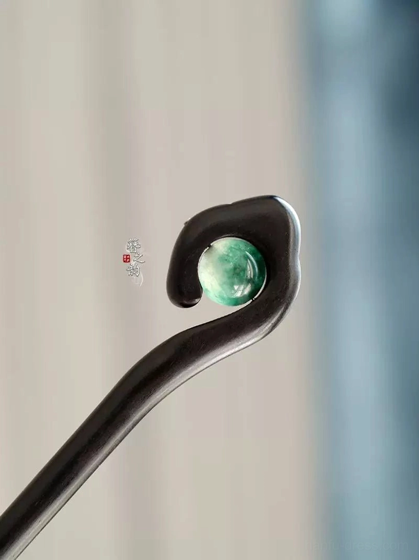 Side close-up of curved cloud-shaped head on Mountain Spirit black wood Chinese hair stick with green stone-style accent