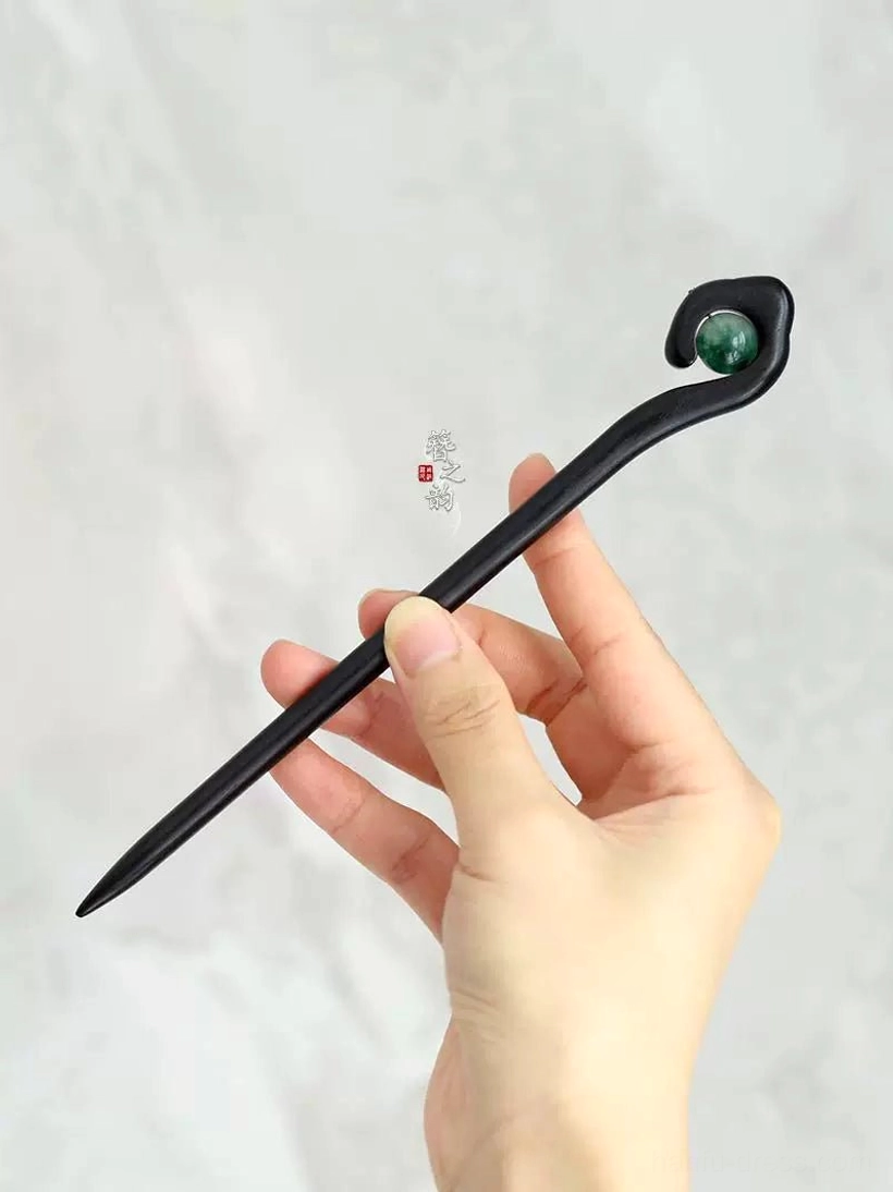 Full view of Mountain Spirit traditional black wood Chinese hair stick held by hand against a light background