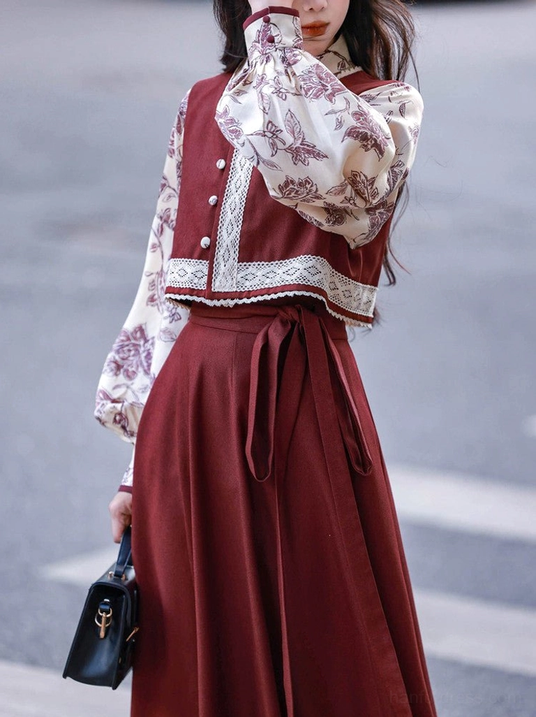 Close detail of burgundy button front vest lace trim floral bishop sleeve blouse and adjustable wrap skirt waist tie