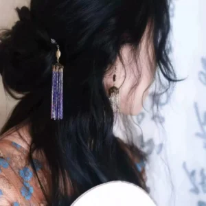 Woman wearing Mysteria purple tassel Chinese hair stick in a low Hanfu bun with matching purple tassel earring styling