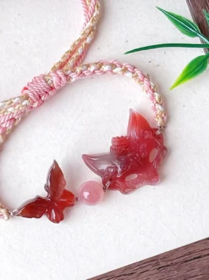 Close-up of natural agate fox spirit Chinese bracelet showing floral carved fox pendant, dimensional red agate butterfly, adjustable braided knot and tassel details