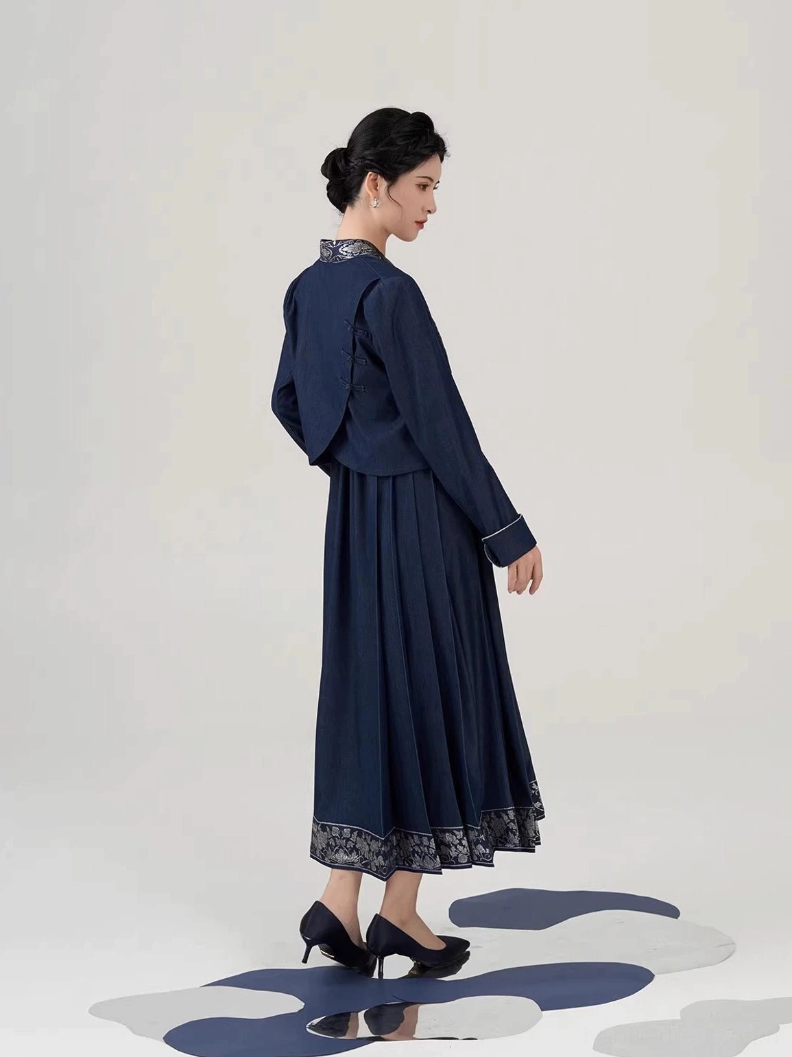 Back view of navy New Chinese Style peony embroidered cropped jacket and pleated mamianqun inspired midi dress set
