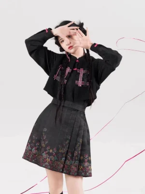 Close-up styling view of the Neon Hanfu-inspired outfit featuring a cropped stand-collar blouse, pink accents, and a pleated printed mini skirt