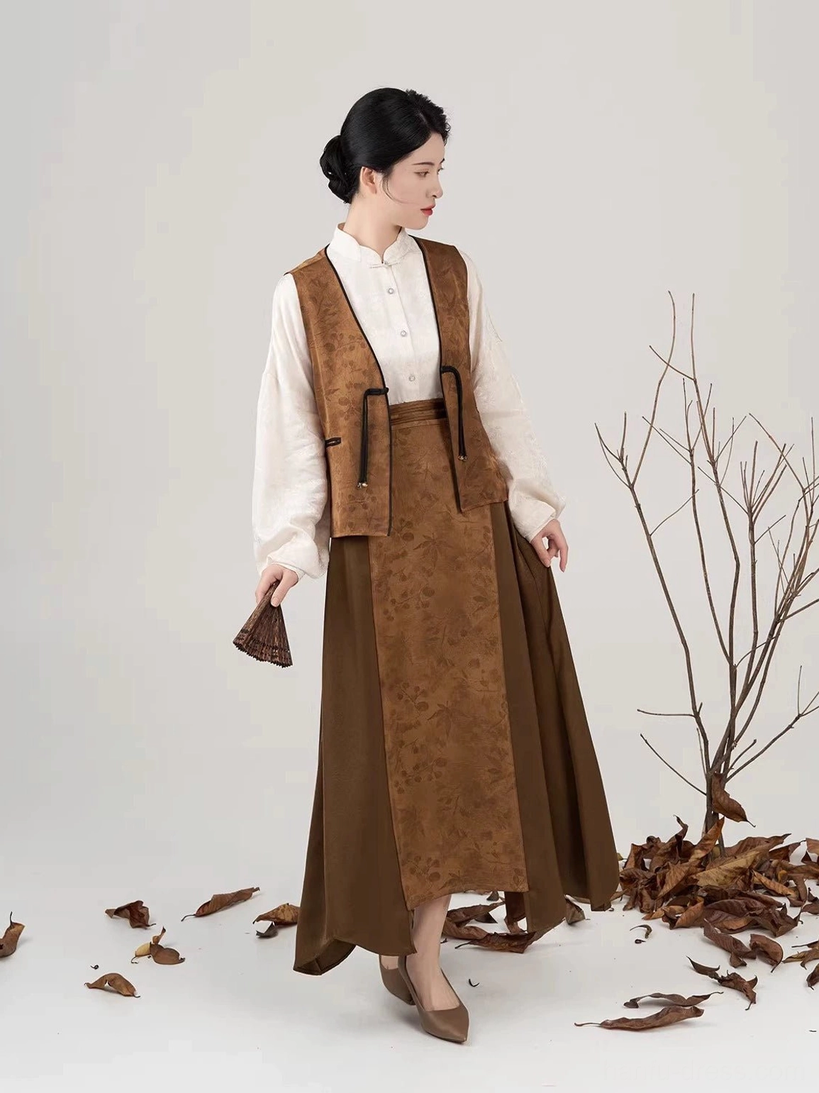Side view of New Chinese style long brown skirt with asymmetric overlapping panel and jacquard vest pockets