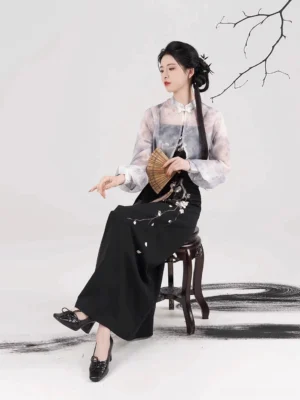 Night Plum Window modern Song Dynasty hanfu set shown in a seated three-quarter view with a sheer ink-wash cropped coat, embroidered camisole, spiral plum blossom skirt, traditional hairstyle, and plum hair ornaments