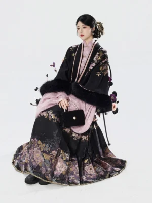 Seated model wearing Nightingale Begonia Ming Dynasty Hanfu set with black printed pipa sleeve jacket and pleated mamianqun skirt