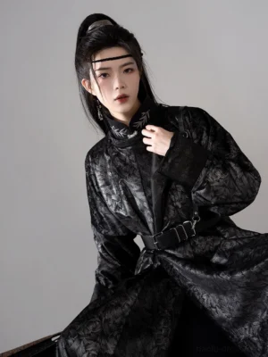 Close-up front view of black jacquard men hanfu robe showing textured floral fabric, embroidered neckline detail, and adjustable metal buckle belt
