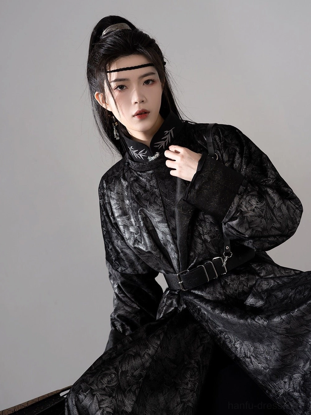 Close-up front view of black jacquard men hanfu robe showing textured floral fabric, embroidered neckline detail, and adjustable metal buckle belt