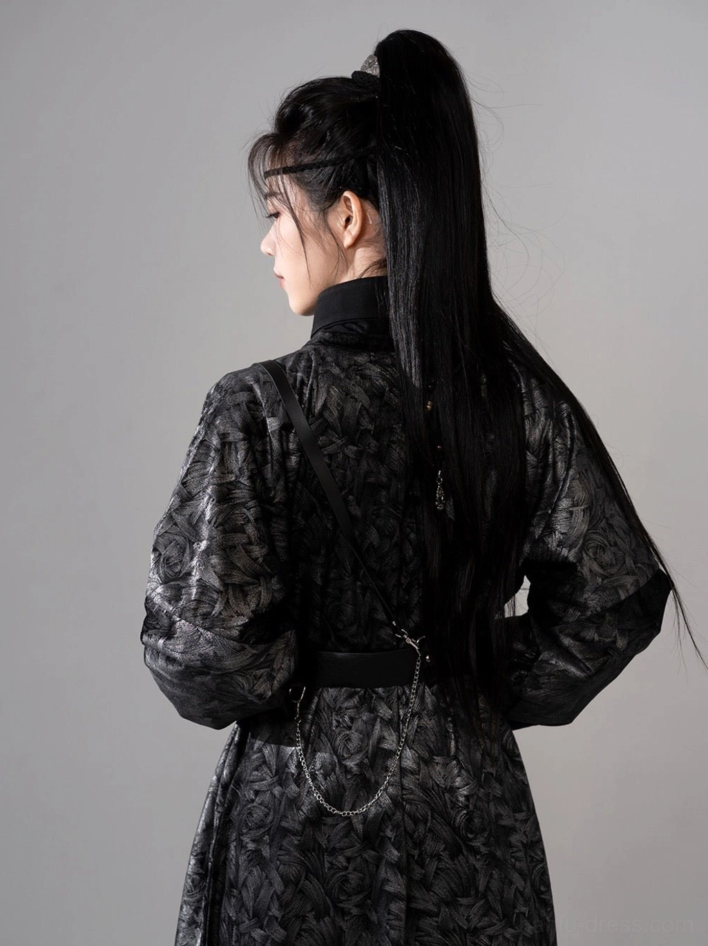 Full back view of gender neutral black Tang Dynasty hanfu robe with all-over floral jacquard pattern, long loose sleeves, waist belt, and dramatic hem