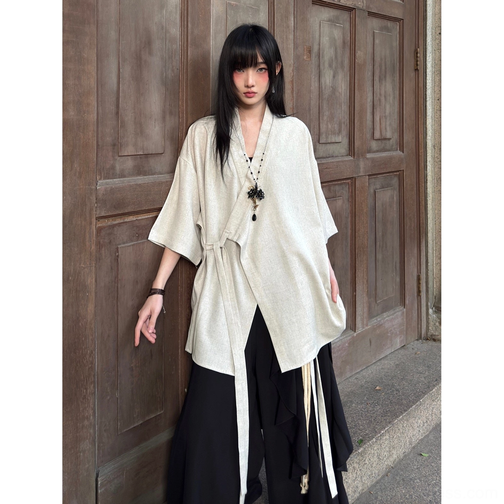 Full-body view of an off-white beige textured modern Hanfu cardigan with long side tie details and relaxed loose silhouette