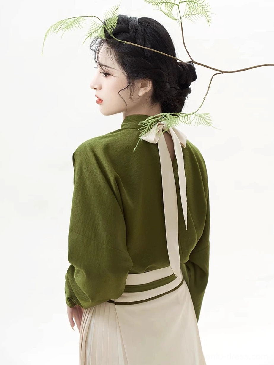 Back view of the olive green Hanfu blouse with its tied neck sash above the cream-toned pleated skirt