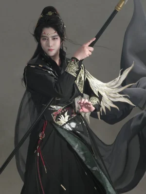 Close up of Onyx Bird male hanfu fantasy costume showing gold embroidered cuffs belt ornaments dark green robe panel and red tassels