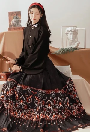 Onyx black modern Hanfu set with stand collar top, gold button details, and Dunhuang-inspired printed mamian skirt shown in a seated studio portrait