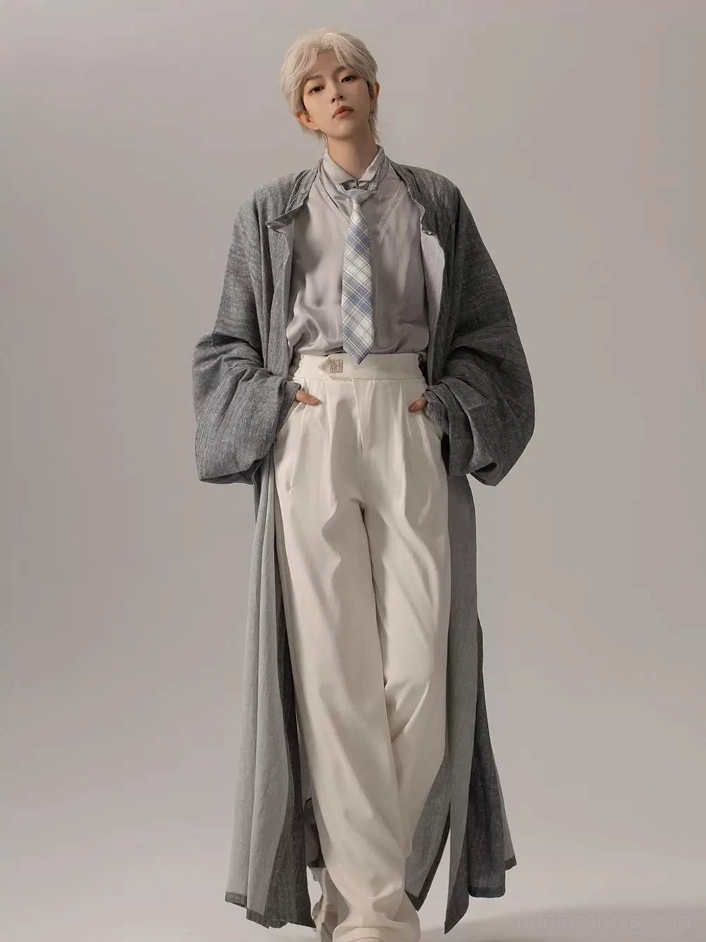 Front full body view of a modern open front Hanfu robe in heather grey styled with a light blue checked necktie, inner shirt, and white trousers