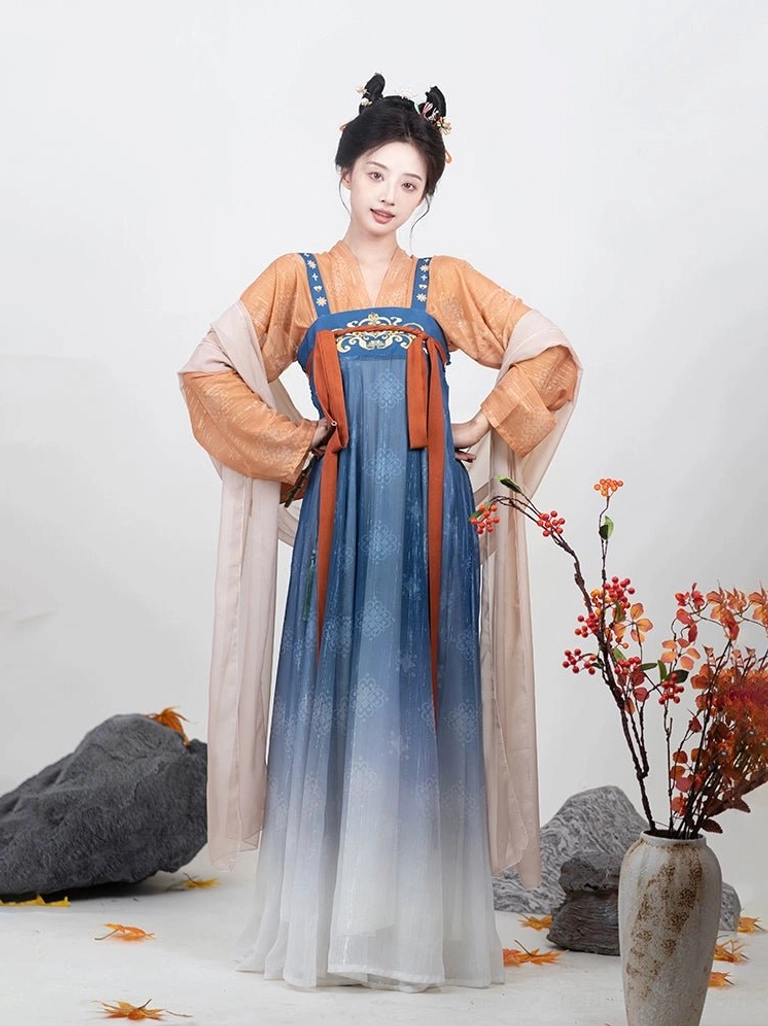 Three-quarter front view of orange blue and ivory Tang Dynasty Qixiong Ruqun Hanfu with flowing skirt and pink shawl