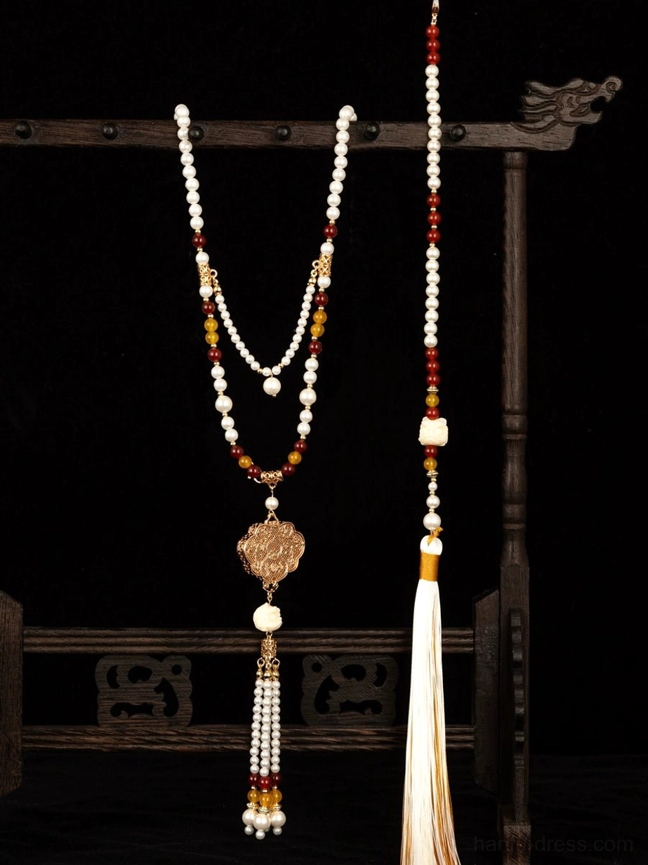 Traditional Chinese Hanfu long tassel pendant necklace displayed on a carved wooden jewelry stand, featuring layered white red and amber beads, a carved bronze Ruyi pendant, and flowing silk tassels