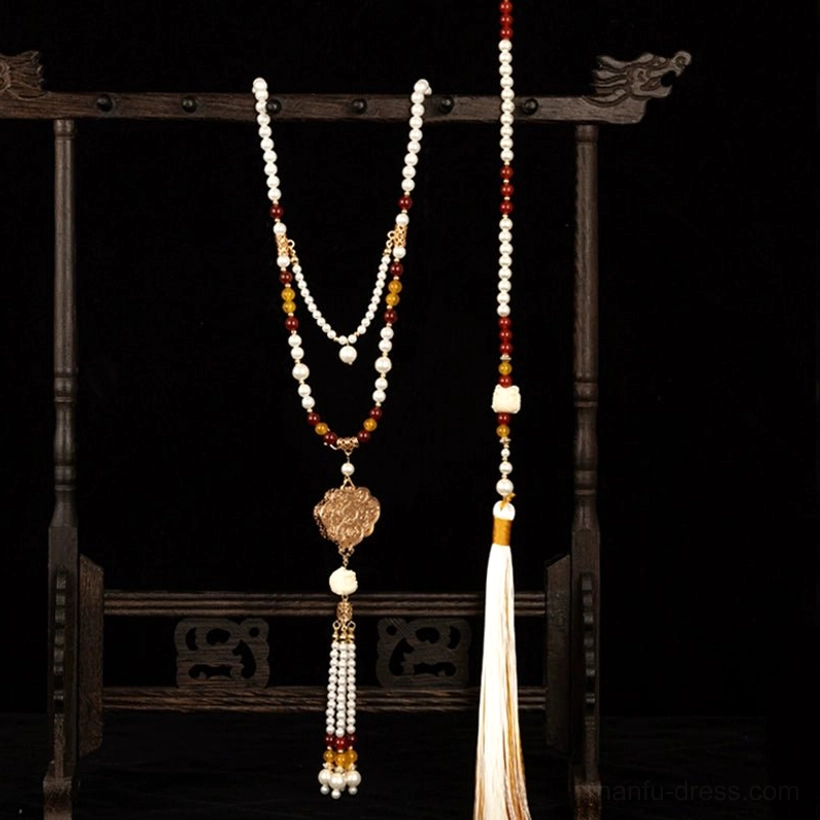 Overall display of an orange evening Chinese style Hanfu tassel necklace with matching beads, Ruyi pendant, layered strands, and flowing traditional tassel decorations
