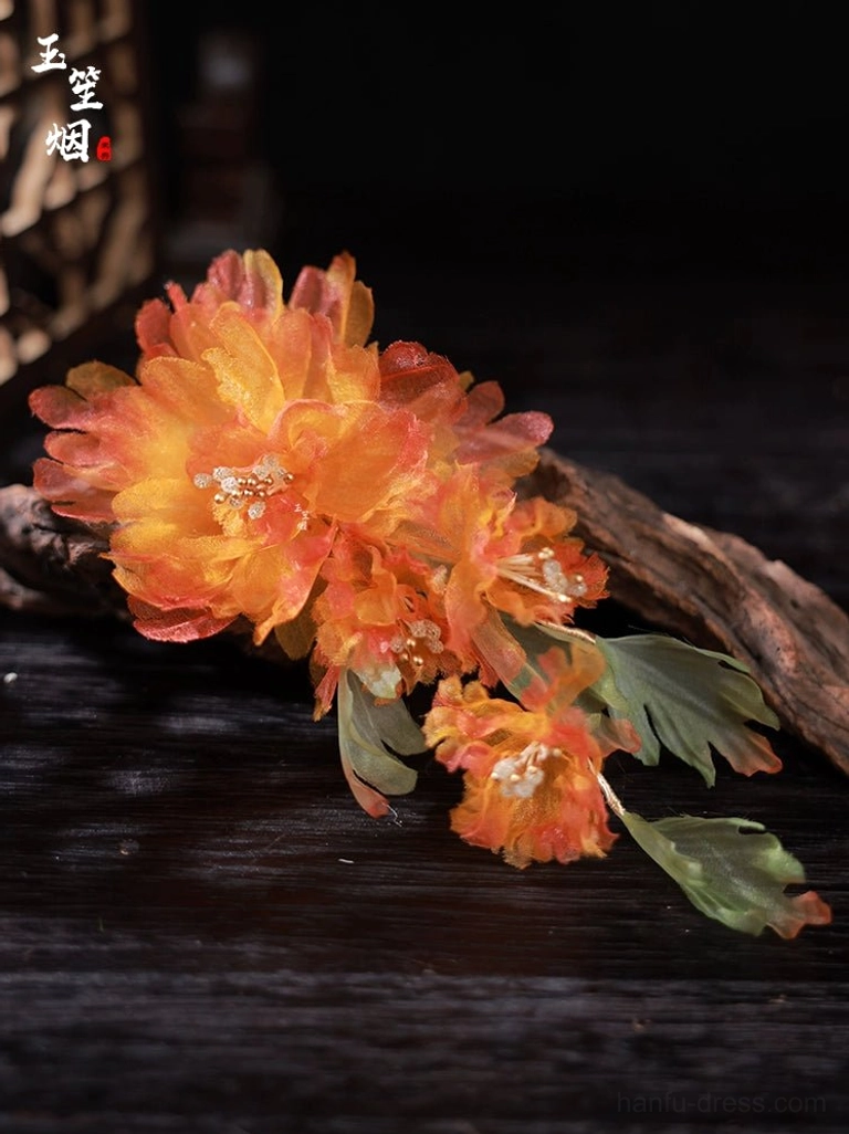 Close-up of orange gradient silk peony hair ornaments with layered petals and green fabric leaves for traditional Chinese Hanfu styling