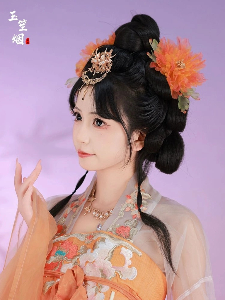 Woman in orange Hanfu wearing a large orange peony hairpin and antique gold forehead crown with dangling pendant in a traditional hairstyle