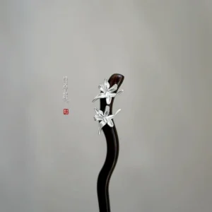 Traditional Chinese hair stick with curved dark wooden shaft and paired silver orchid flowers on a light gray background