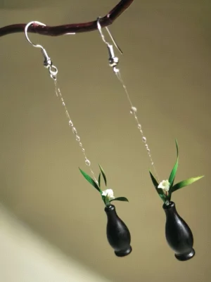 Pair of orchid in vase Chinese dangle earrings with white blossoms green foliage black vases and silver hooks on twig