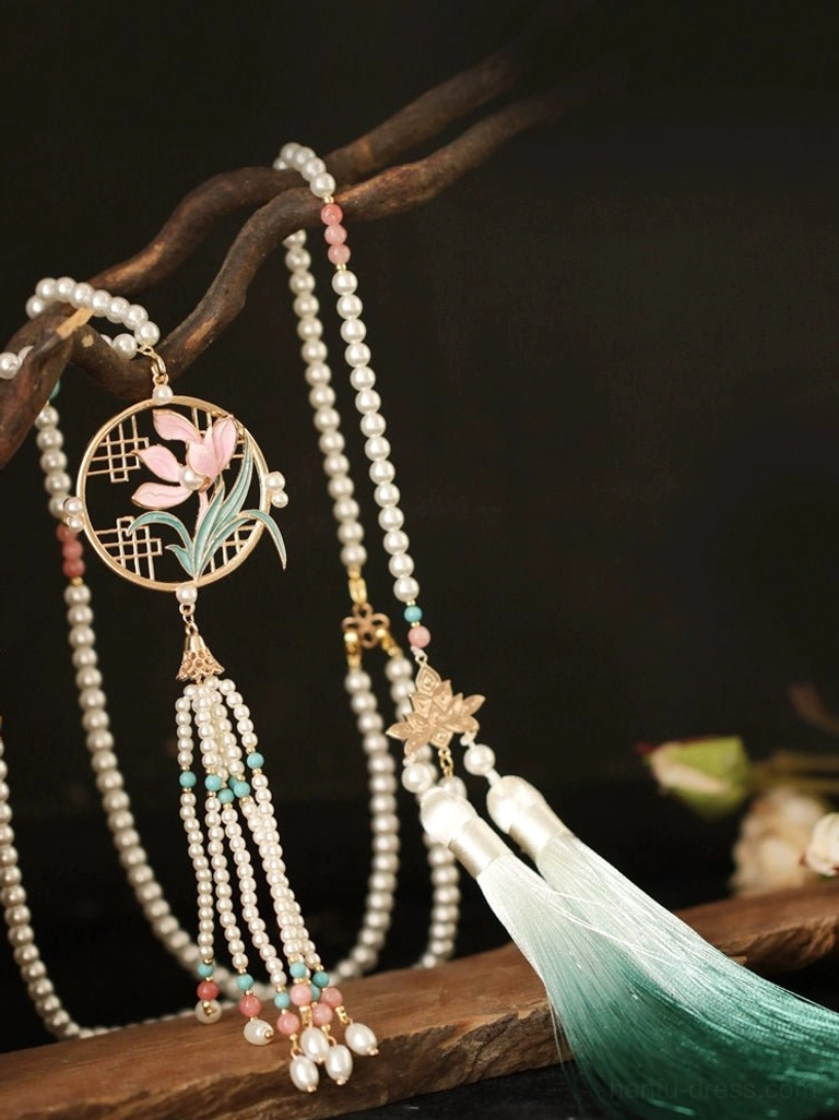 Complete orchid yingluo Chinese necklace flat lay with circular floral pendant, freshwater pearl strands, leaf charm and gradient green tassels