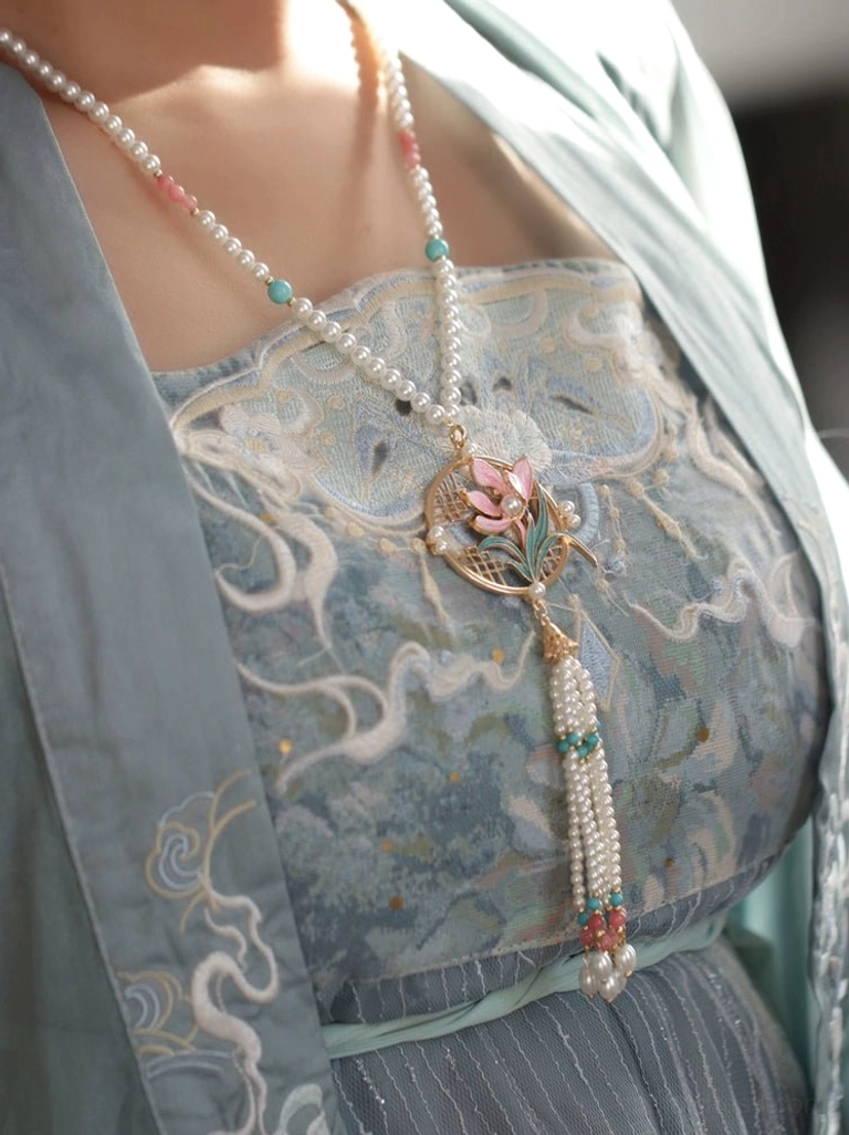 Orchid yingluo Chinese necklace worn at the neckline with light blue embroidered Hanfu and delicate pearl bead chain