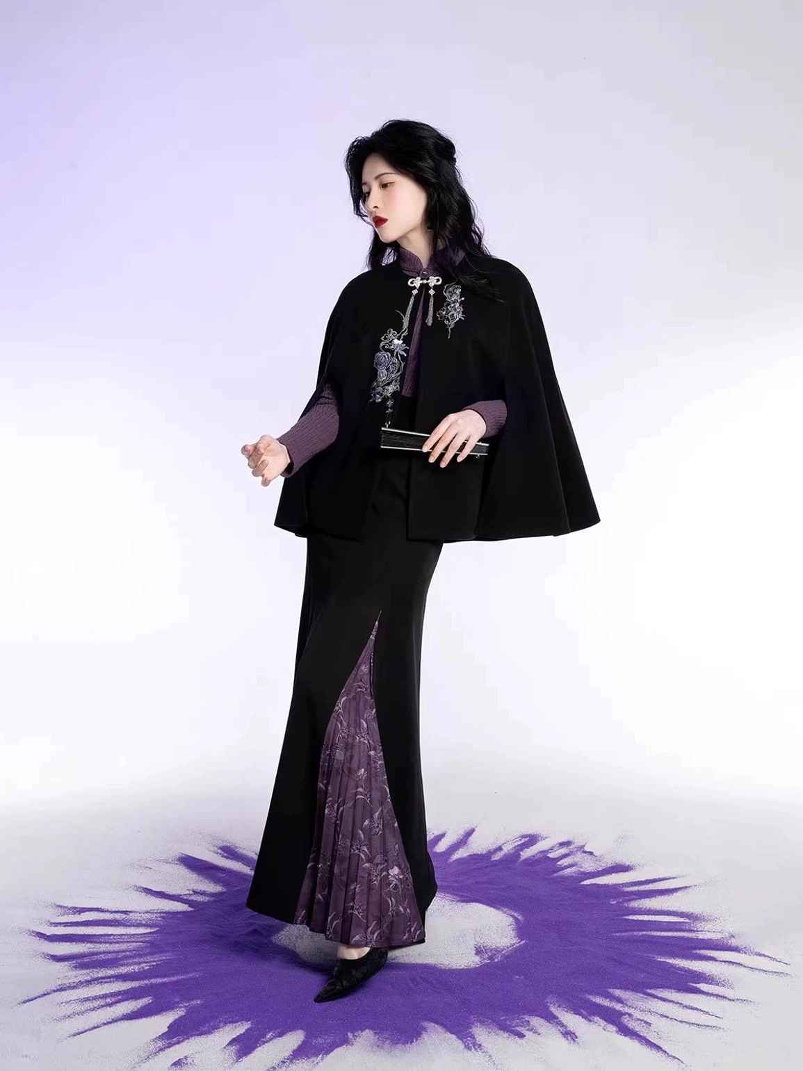 Oblique side view of Oriental Witch Chinese style Hanfu outfit with embroidered black cape purple skirt details and clutch styling