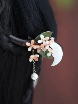 Osmanthus crescent moon Chinese hair stick worn in a braided Hanfu updo with pink flowers and pearl tassel