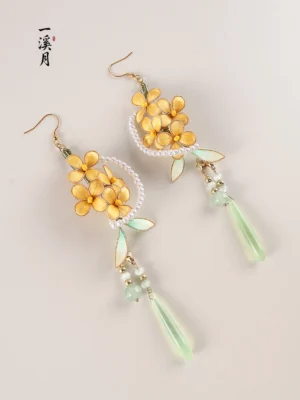 Oblique studio view of osmanthus flower Hanfu dangle earrings with gold-tone blossoms pearl-style rings green foliage and pale green jade-look tassel drops