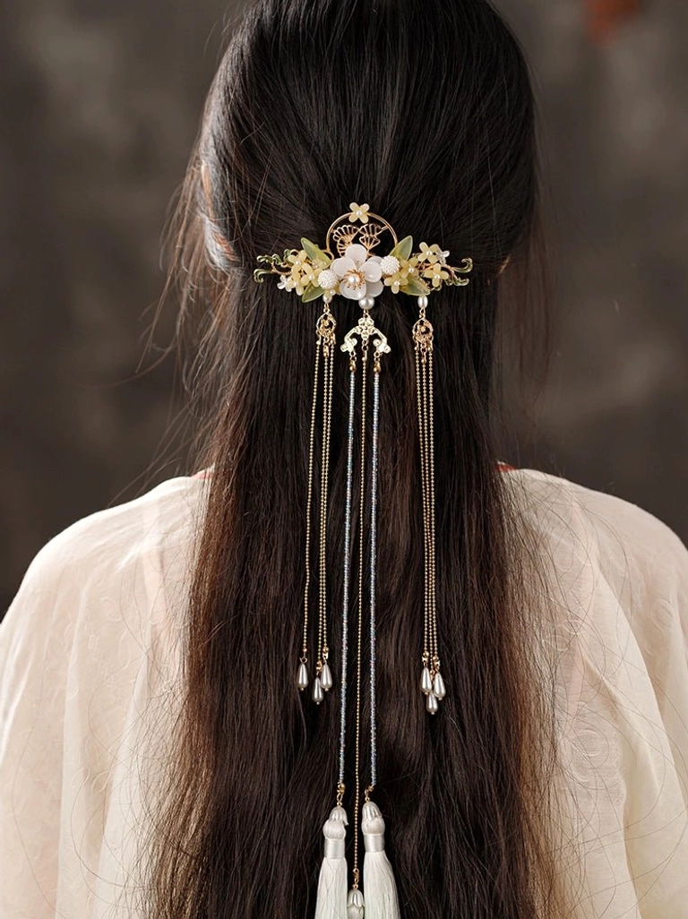 Back view of a woman wearing a Chinese Hanfu back hair pin with osmanthus-inspired gold floral frame, white decorative accents, and shorter dangling chain tassels